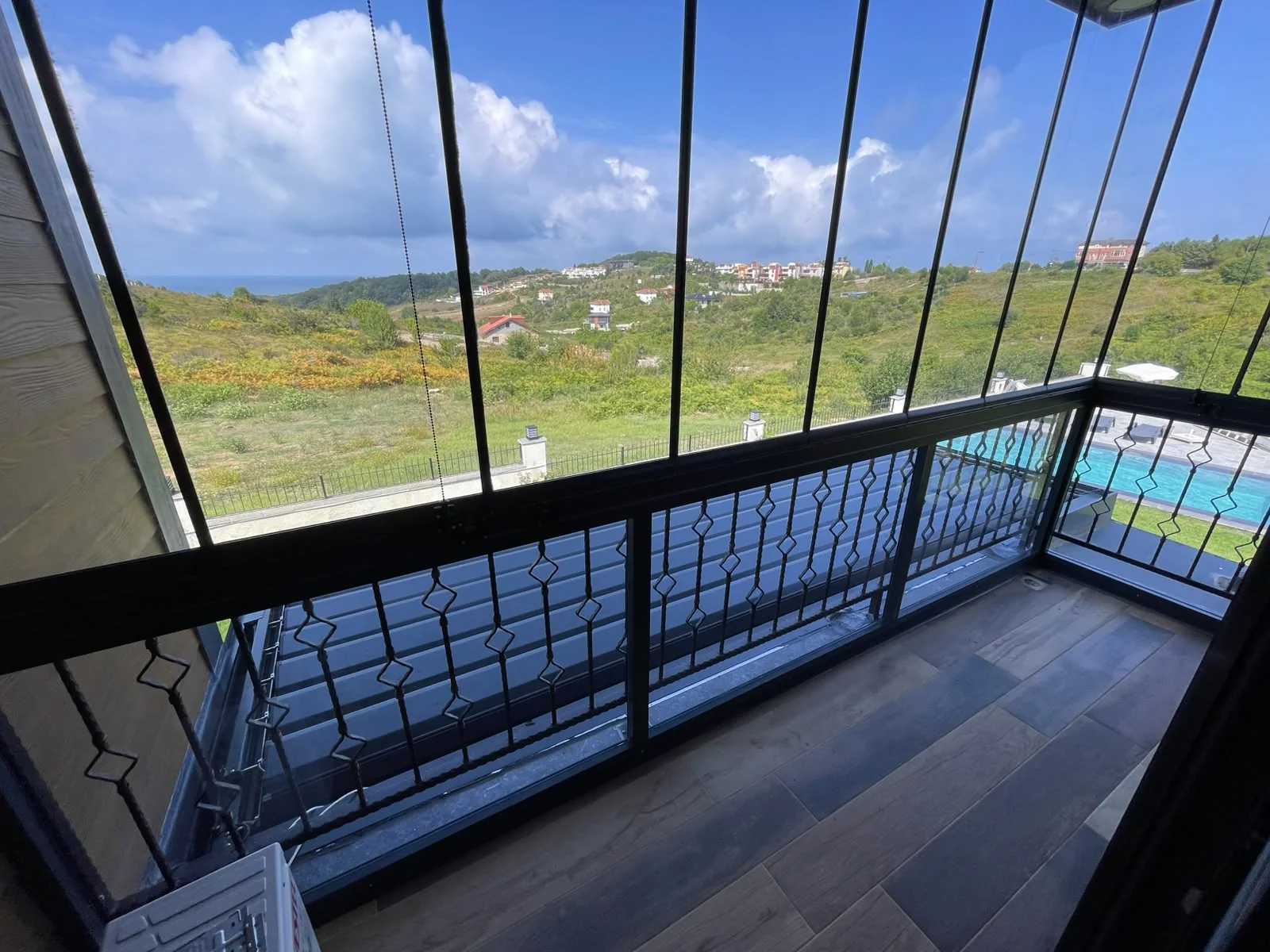 Şehir manzaralı rezidans terasında cam balkon detayı 2